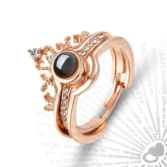 Rose gold adjustable ring with crown embellishment and I love you magnifying ball in the center